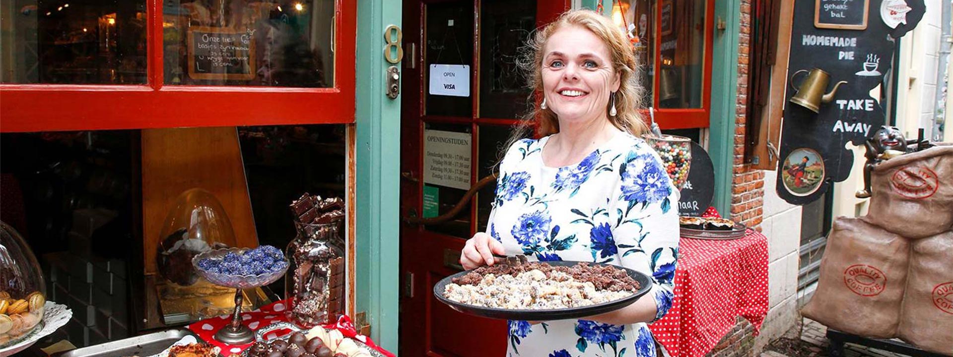 woman outside shop holding cake