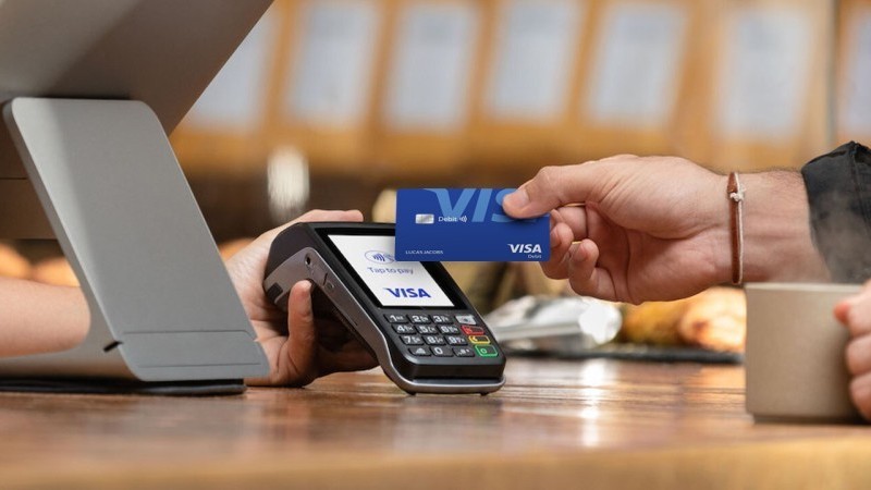 person paying with visa card contactless