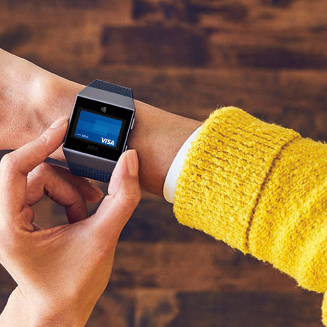 Woman using Visa Token on a Fitbit smartwatch.
